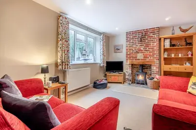 a living room with two red chairs and a fireplace at 3 Bed in Middleton oc-htv in Middleton