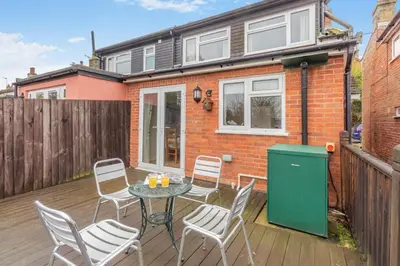 a patio with a table and chairs on a wooden deck at 3 Bed in Middleton oc-htv in Middleton
