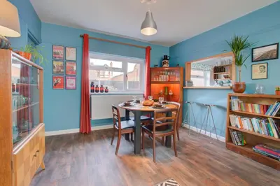 a dining room with blue walls and a table and chairs at 2 Bed in Felixstowe oc-hideo in Felixstowe