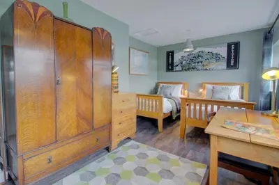 a bedroom with a large wooden cabinet and a bed at 2 Bed in Felixstowe oc-hideo in Felixstowe