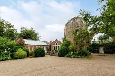 an old stone house with an arch in the yard at 2 Bed in Tunstall oc-ivylod in Rendlesham