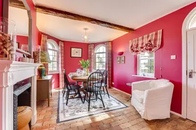 a dining room with red walls and a table and chairs at 2 Bed in Tunstall oc-ivylod in Rendlesham