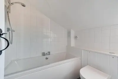 a white bathroom with a tub and a toilet at 1 Bed in Wenhaston oc-jap in Wenhaston