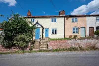 an old brick house with blue doors and stairs at 1 Bed in Wenhaston oc-jap in Wenhaston