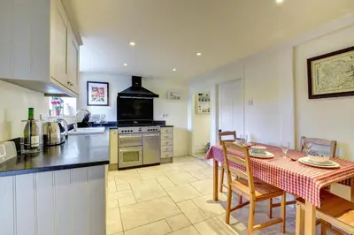 a kitchen with a table and a kitchen with a stove at 2 Bed in Orford oc-sflis in Orford
