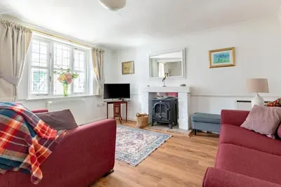 a living room with a red couch and a fireplace at 2 Bed in Friston oc-lcq in Friston