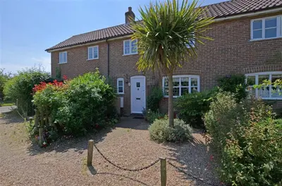 a brick house with a palm tree in front of it at 2 Bed in Friston oc-lcq in Friston