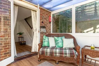 a porch with a wicker chair and a window at 2 Bed in Friston oc-lcq in Friston