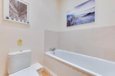 a white bathroom with a toilet and a bath tub at 4 Bed in Halesworth oc-mdh in Blythburgh