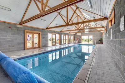 a large swimming pool in a building with a ceiling at 4 Bed in Halesworth oc-mdh in Blythburgh