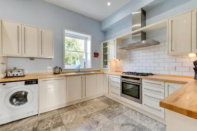 a kitchen with white cabinets and a washer and dryer at 4 Bed in Halesworth oc-mdh in Blythburgh