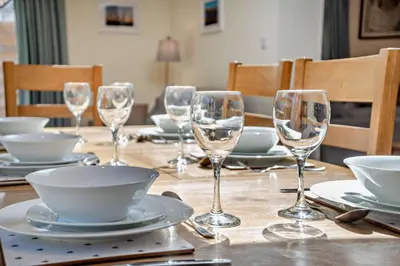 a table with wine glasses and plates on it at 7 Bed in Aldeburgh oc-midba in Aldeburgh