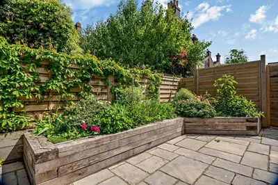 a garden with a wooden fence and flowers at 7 Bed in Aldeburgh oc-midba in Aldeburgh