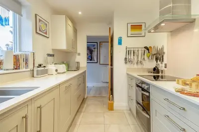 a large kitchen with white cabinets and a sink at 3 Bed in Westleton oc-egv in Westleton