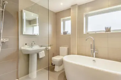 a bathroom with a tub and a sink and a toilet at 3 Bed in Westleton oc-egv in Westleton