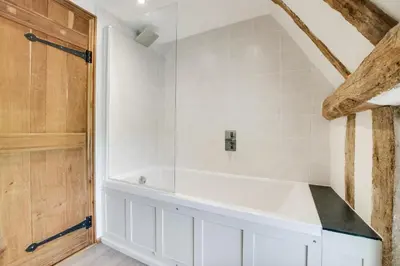 a bathroom with a white tub and white tiles at 5 Bed in Finningham oc-obhf in Finningham