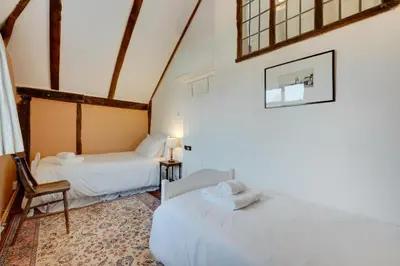 a room with two beds and a chair in it at 4 Bed in Orford oc-obh2 in Orford