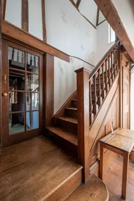 a room with a wooden staircase and a table at 4 Bed in Orford oc-obh2 in Orford
