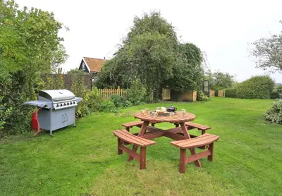 a picnic table and a grill in a yard at 4 Bed in Orford oc-obh2 in Orford