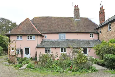 a pink house with a garden in front of it at 4 Bed in Orford oc-obh2 in Orford