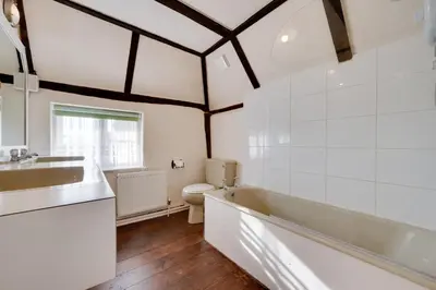 a bathroom with a tub and a toilet and a sink at 4 Bed in Orford oc-obh2 in Orford