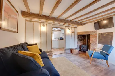 a living room with a blue couch and a fireplace at 2 Bed in Saxtead oc-pera in Saxtead