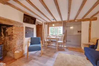 a living room with a table and chairs and a brick wall at 2 Bed in Saxtead oc-pera in Saxtead