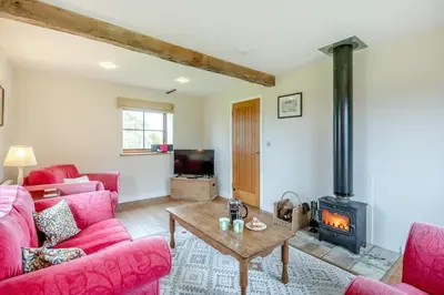 a living room with pink furniture and a wood stove at 2 Bed in Yoxford oc-hploug in Yoxford
