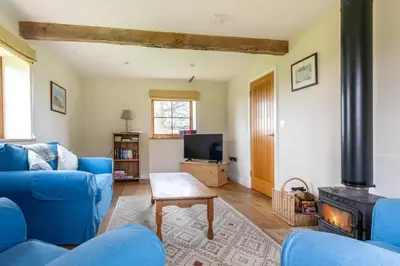 a living room with a blue couch and a fireplace at 2 Bed in Yoxford oc-hploug in Yoxford