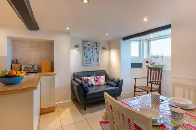 a kitchen and living room with a table and a couch at 3 Bed in Aldeburgh oc-reg in Aldeburgh