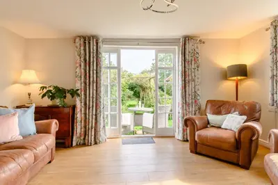 a living room with a couch and a chair and a sliding glass door at 2 Bed in Saxmundham oc-rvr in Snape