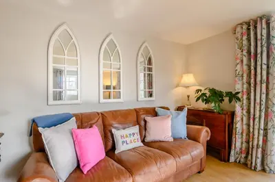 a living room with a brown leather couch with pillows at 2 Bed in Saxmundham oc-rvr in Snape