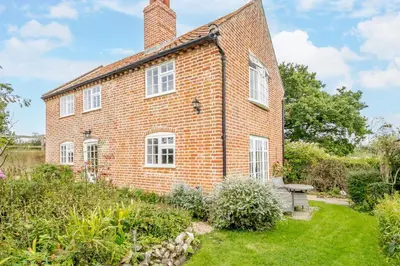 an exterior view of a brick house with a garden at 2 Bed in Saxmundham oc-rvr in Snape