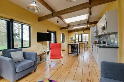 a kitchen and living room with wooden floors and chairs at 2 Bed in Haughley oc-strb in Haughley
