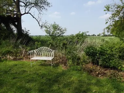 a white bench sitting in the grass in a field at 2 Bed in Haughley oc-strb in Haughley