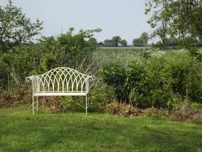a white bench sitting in the grass in a field at 2 Bed in Haughley oc-strb in Haughley