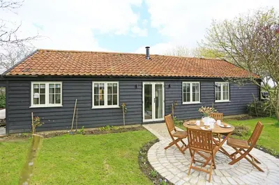 a small blue house with a table and chairs at 2 Bed in Eye oc-slo in Wilby