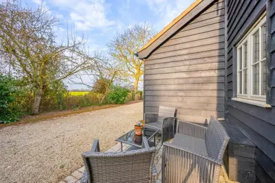 a patio with chairs and a fire hydrant next to a house at 2 Bed in Eye oc-slo in Wilby