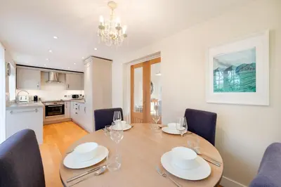 a dining room with a table and chairs and a kitchen at 2 Bed in Eye oc-slo in Wilby