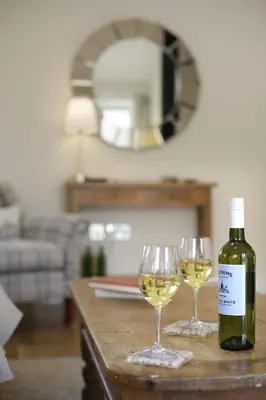 a bottle of wine and two wine glasses on a table at 3 Bed in Wilby oc-slowlo in Wilby