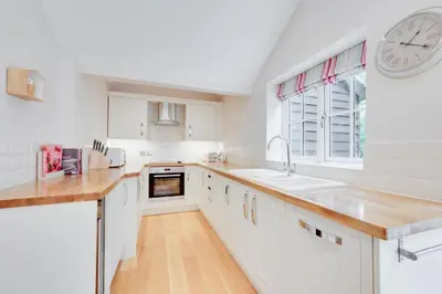 a kitchen with white cabinets and a clock on the wall at 3 Bed in Wilby oc-slowlo in Wilby