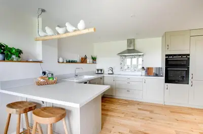 a kitchen with white cabinets and a kitchen island with stools at 2 Bed in Newton oc-swro in Sudbury