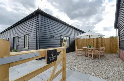 a small black house with a table and an umbrella at 2 Bed in Newton oc-swro in Sudbury
