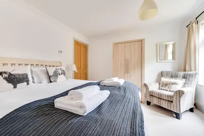 a bedroom with a large bed with towels on it at 4 Bed in Thorpeness oc-cho in Thorpeness