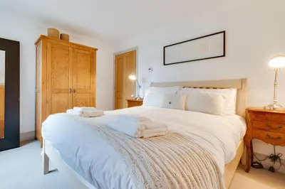 a bedroom with a large white bed with towels on it at 4 Bed in Thorpeness oc-cho in Thorpeness