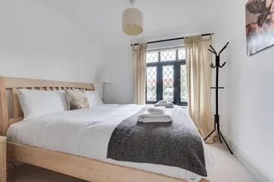 a bedroom with a bed with white sheets and a window at 4 Bed in Thorpeness oc-cho in Thorpeness
