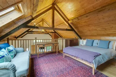 a bedroom with a bed and a couch in a attic at 3 Bed in Debenham oc-thefol in Debenham