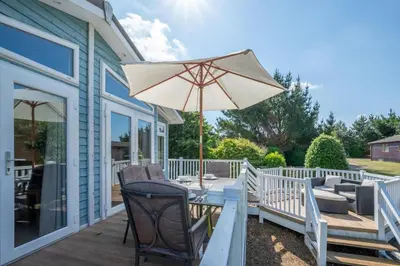 a patio with a table and an umbrella at 2 Bed in Aldeburgh oc-har in Aldeburgh