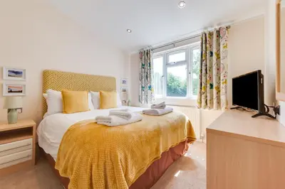 a bedroom with a large bed and a television at 2 Bed in Aldeburgh oc-har in Aldeburgh