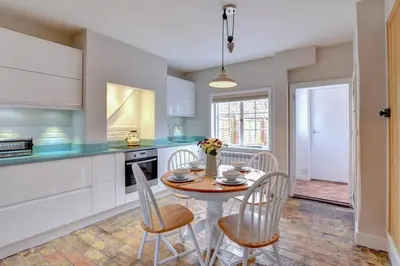 a kitchen with a table and chairs in a kitchen at 2 Bed in Orford oc-sflpo in Orford
